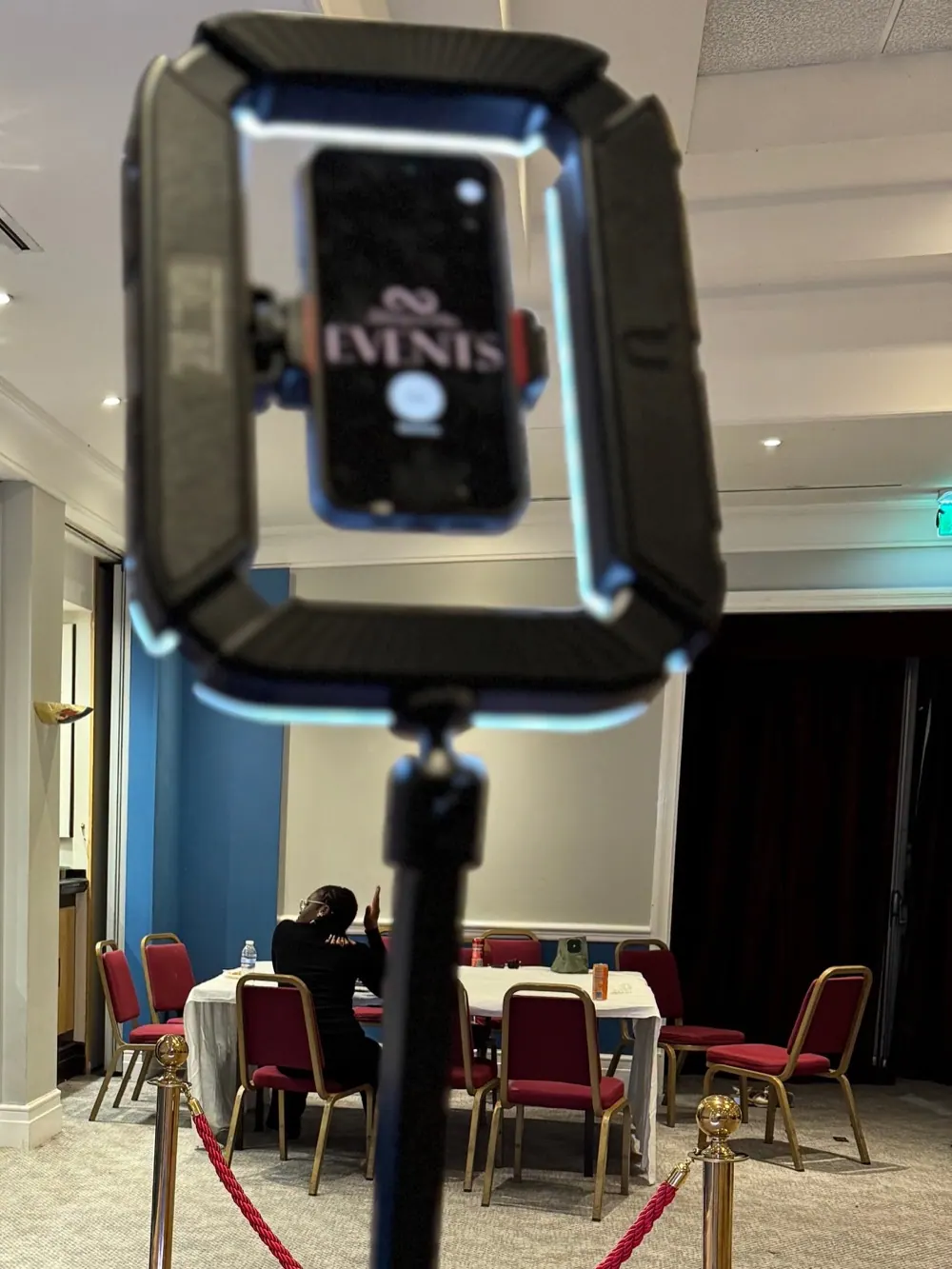 360 video booth camera arm with a ring light holding a phone in an event room